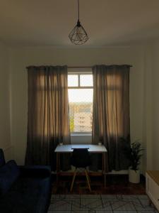 un salon avec une table et une fenêtre dans l'établissement Apto central, com vista deslumbrante!, à Curitiba