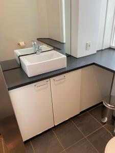 W łazience znajduje się biała umywalka i blat. w obiekcie Frederiksberg Apartments 438 w Kopenhadze