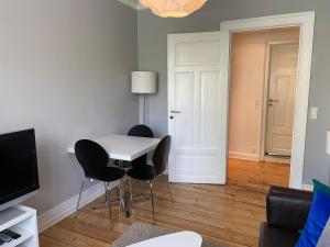 ein Wohnzimmer mit einem weißen Tisch und Stühlen in der Unterkunft Frederiksberg Apartments 438 in Kopenhagen