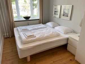białe łóżko w pokoju z oknem w obiekcie Frederiksberg Apartments 438 w Kopenhadze
