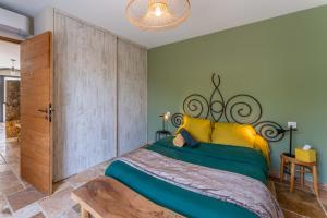 ein Schlafzimmer mit einem großen Bett in Gelb und Grün in der Unterkunft Villa La Mireio in Malaucène