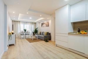 cocina y sala de estar con sofá y mesa en GENESIS APARTMENT IN MADRID, en Madrid