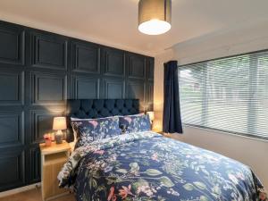 a bedroom with a bed with a blue headboard at Handale Banks Farm Lodge in Saltburn-by-the-Sea