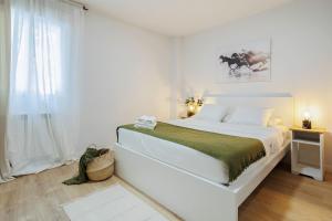 GENESIS APARTMENT IN MADRID في مدريد: غرفة نوم بيضاء مع سرير كبير ونافذة