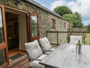 a patio with a table and chairs on a deck at Nant Glas in Llanwrda
