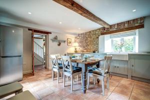 a kitchen with a wooden table and chairs at Hutts Bothy in Oxford