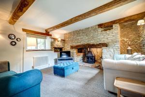 a living room with a stone fireplace and a blue couch at Hutts Bothy in Oxford