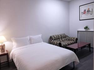 - une chambre avec un lit blanc et un canapé dans l'établissement Cozy Private Rm Heart of North York Free Parking Full Kitchen Close to Downtown, à Toronto