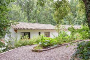 a house in the woods with a gravel driveway at PAUSE NATURE. Maison Ananda à 14 kms de Toulouse avec parking privatif in Lapeyrouse-Fossat