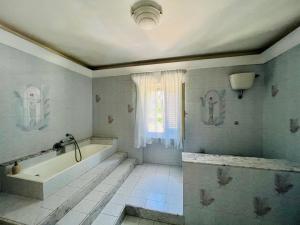 baño con bañera y ventana en Be Your Home - Villa Rosi, en Civitavecchia