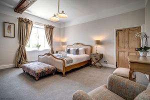 a bedroom with a bed and a chair and a table at Greenhill Farmhouse in Bletchingdon