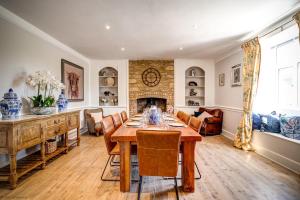 a dining room with a table and a fireplace at Greenhill Farmhouse in Bletchingdon