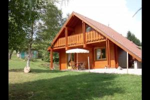 a wooden cabin with a table and an umbrella at Chalet Les 2 Bouleaux à 2 pas de GERARDMER et des lacs in Xonrupt-Longemer