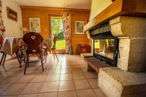 a living room with a fireplace and a table and chairs at Chalet Le Pin in Xonrupt-Longemer