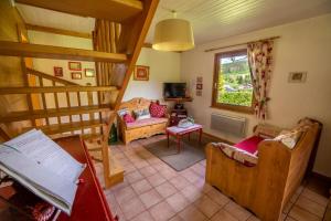 a living room with a staircase and a living room with chairs at Chalet Le Pin à 2 pas de GERARDMER, dans la vallée des lacs in Xonrupt-Longemer