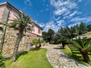 una casa de piedra con una palmera al lado de un edificio en Be Your Home - Villa Rosi, en Civitavecchia