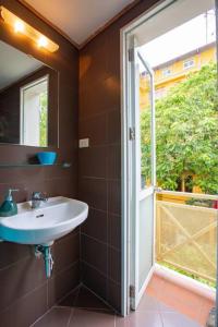 een badkamer met een wastafel en een raam bij L'Amant Homestay in Hanoi