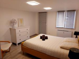 Un dormitorio con una cama con un osito de peluche. en MONTALIEU SEJOUR Rez de jardin Les jonquilles - 1 à 4 PERS - PROX CNPE BUGEY - VALLEE BLEU - VIA RHONA, en Montalieu-Vercieu