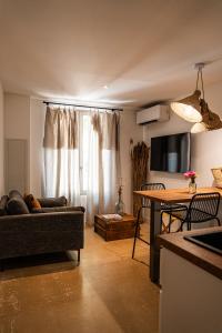 a living room with a couch and a table at Maison Arthur in Aigues-Mortes