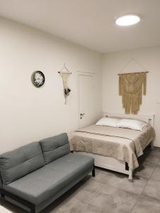 - une chambre avec un lit, un canapé et un réveil dans l'établissement Dekel Dom Baharava, à Beʼer Ora