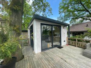 a tiny house with a large deck at Camping de Vinkenkamp in Lieren