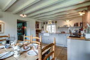 Una cocina con una mesa y sillas en una habitación. en Church End Cottage, en Swerford