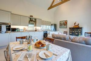 a kitchen and living room with a table and a couch at Dairy Lodge in Bladon