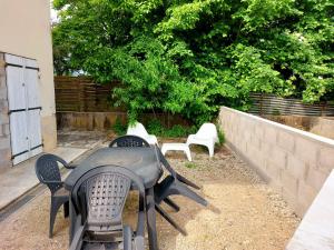 un grupo de mesas y sillas en un patio en MONTALIEU SEJOUR Rez de jardin Les jonquilles - 1 à 4 PERS - PROX CNPE BUGEY - VALLEE BLEU - VIA RHONA, en Montalieu-Vercieu