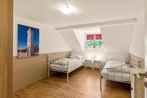 a bedroom with two beds and a table and a lighthouse at Grashaus Upleward in Krummhörn