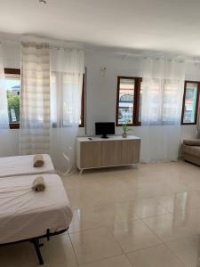 a room with two beds and a television in it at Casa los Pinos Calpe Playa in Calpe