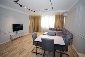 a living room with a table and a couch at Miku Apartment -Outstanding Apartment at Taiwan in Tirana