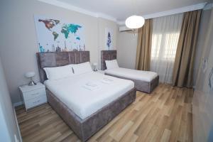 1 Schlafzimmer mit 2 Betten und einer Karte an der Wand in der Unterkunft Miku Apartment -Outstanding Apartment at Taiwan in Tirana