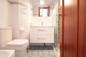 ein weißes Badezimmer mit Toilette und Waschbecken in der Unterkunft Global Properties, Apartamento en primera linea de playa, Canet de Berenguer in Canet d'en Berenguer + 58 Fotos