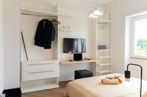 a bedroom with a bed and a desk and a television at Don Gaetano Apartment - Nel Cuore di Napoli in Naples