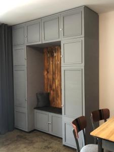 a closet with white cabinets and a table and chairs at Villa Karabelli in Búč