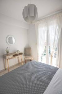 sypialnia z łóżkiem, stołem i oknem w obiekcie Ten Suns 5 w Lixoúrion