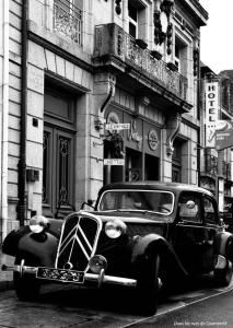 een zwart-witte foto van een auto geparkeerd op straat bij Hôtel Vintage in Quimperlé