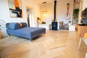a living room with a blue couch and a wooden floor at Cute Beach House Zandvoort in Zandvoort +16 photos