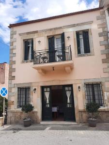 a building with a balcony on top of it at Villa 1930 ground floor in Vóroi