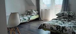 1 dormitorio con 1 cama, 1 silla y 1 ventana en Pokoje, en Maniowy