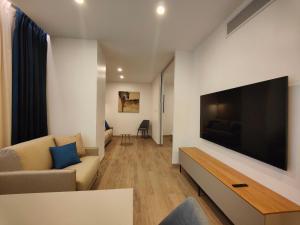 sala de estar con TV de pantalla plana grande en Carducci Art Guesthouse, en Oristano