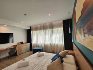 Habitación de hotel con cama y TV en Carducci Art Guesthouse en Oristano
