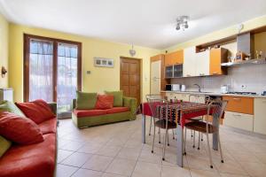 una cucina e un soggiorno con tavolo e sedie di Colorful Apartment a Colico