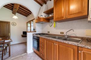 uma cozinha com armários de madeira e um lavatório em Pugnano Alto - appartamento Grano em Lisciano Niccone