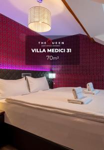 Una cama en una habitación con un cartel que lee la villa medici con cama grande en The Queen Luxury Apartments - Villa Medici, en Luxemburgo