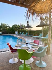 een tafel en stoelen naast een zwembad bij La Villa Sauvage in Essaouira