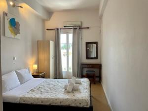 a bedroom with a bed with a teddy bear on it at HB Hotel Benitsa in Benitses