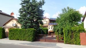 アウグストゥフにあるDwupokojowe mieszkanie z balkonemの塀と木の前の家