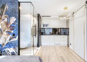 1 dormitorio con armarios blancos y pared azul en A&J APARTS GDYNIA en Gdynia