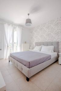 a white bedroom with a large bed in a room at Ten Suns 9 in Lixouri